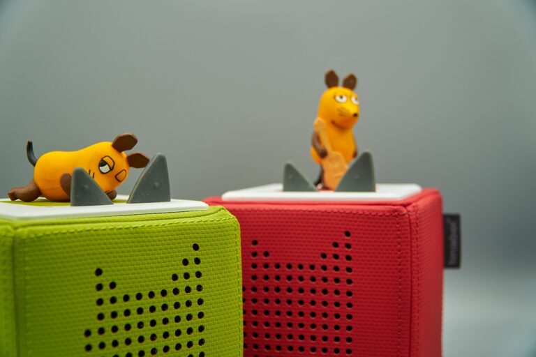 Kind hält Toniebox bedient sie spielerisch und hört Hörspiel Inhalte